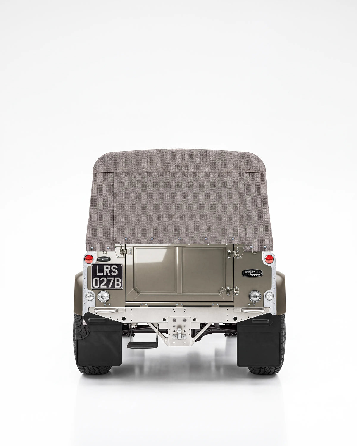 Rear view of the Arden Green Defender 90 with its handmade brown soft top