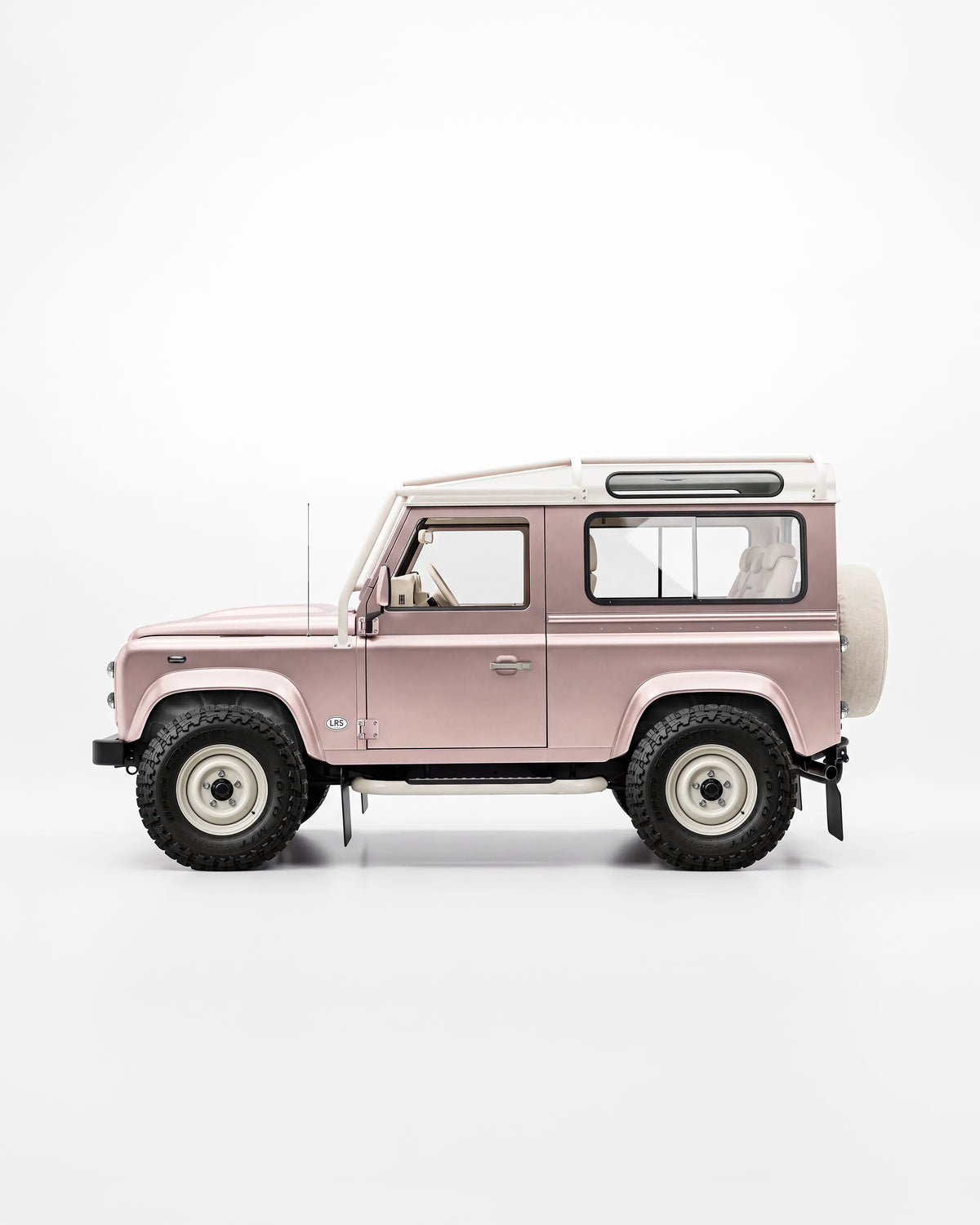 Side profile of a pink Defender 90 with a matching hardtop and white wheels