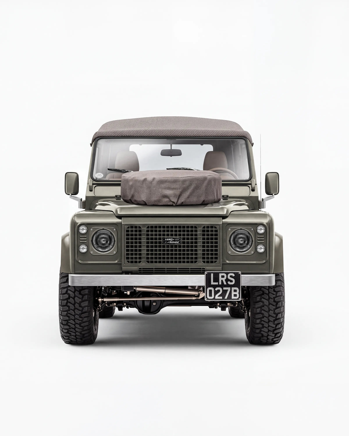 Front view of the Arden Green Defender 90 with its brown soft top and bonnet spare-wheel cover