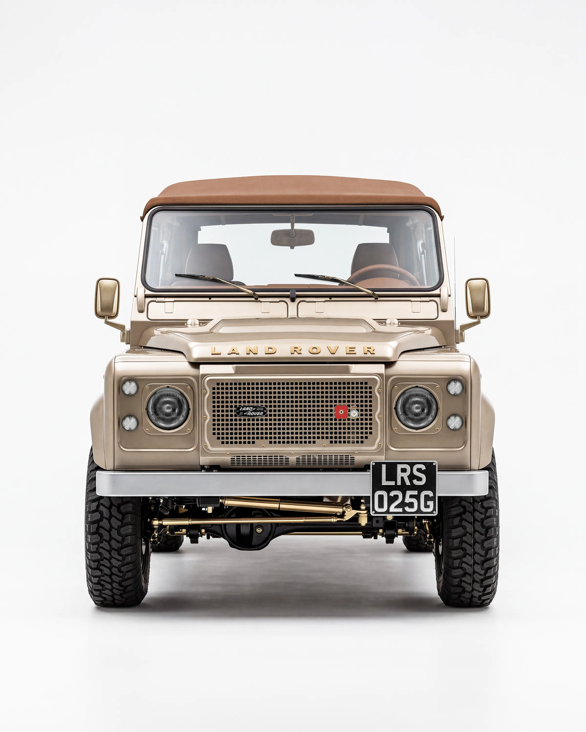 Front view of the Golden Sand Defender 90 with its brown soft top