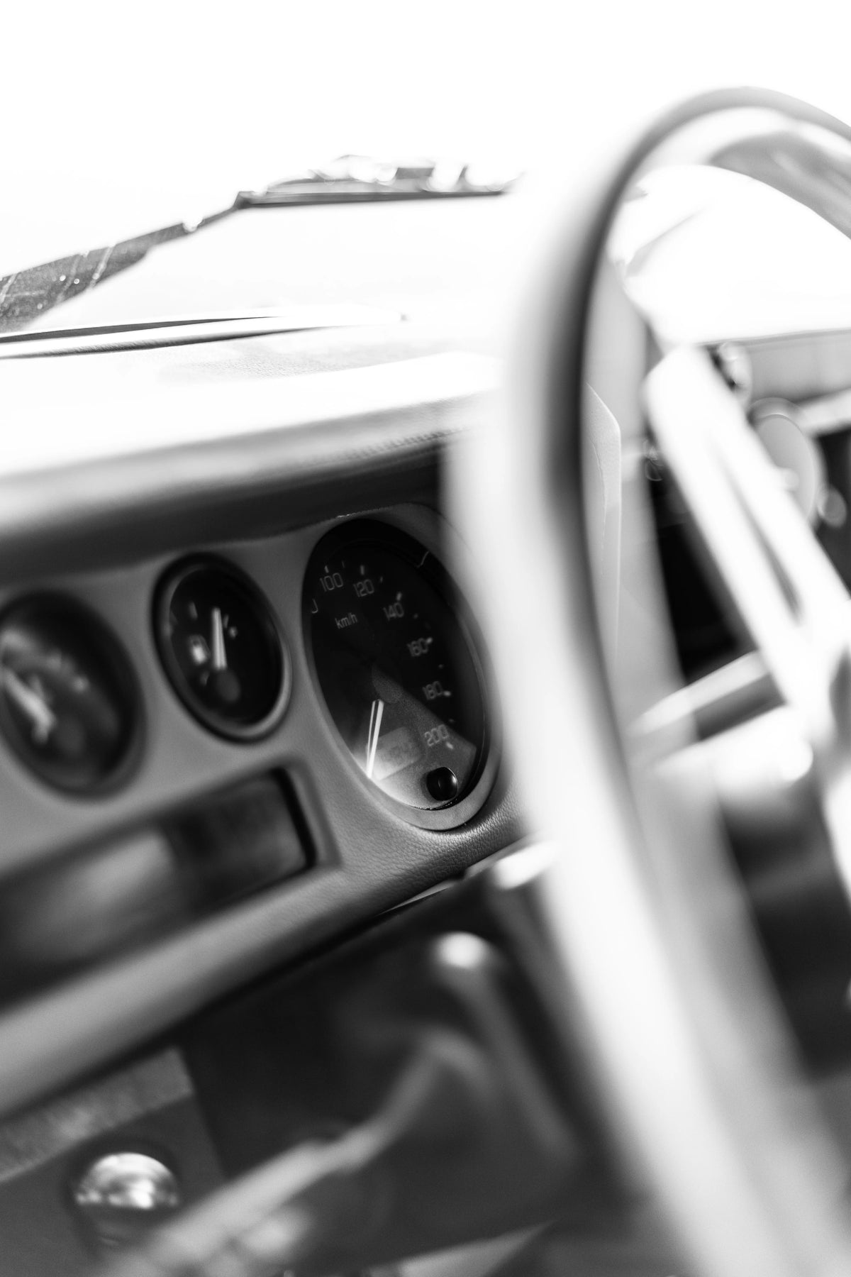 Black-and-white detail of the Miami Blue Defender 110 dashboard, instruments and steering wheel