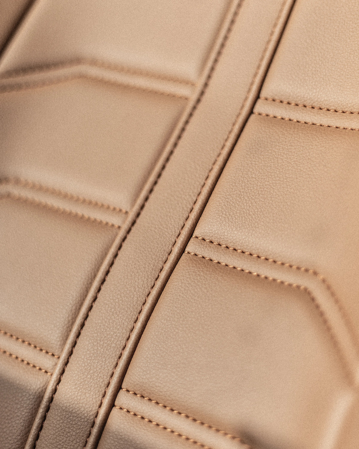 Close-up of terracotta leather upholstery with stitched panels in the Miami Blue Defender 110