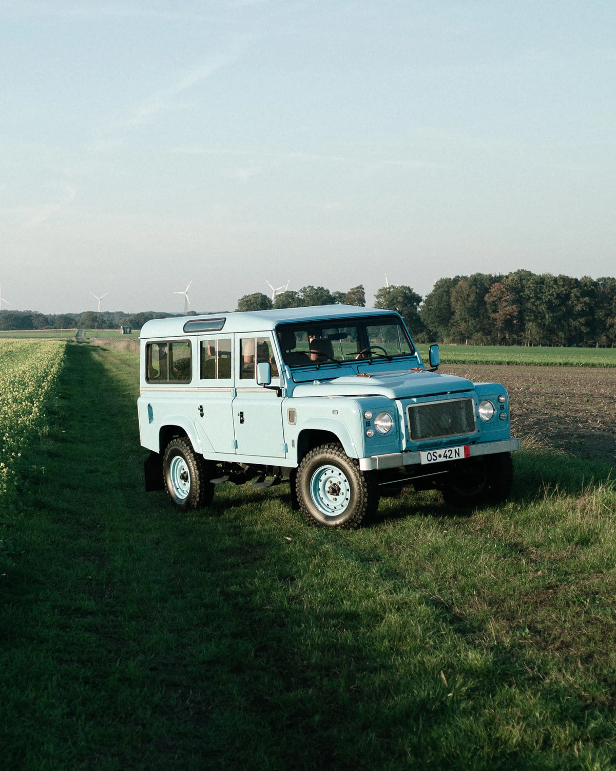 Front three-quarter view of the Miami Blue Defender 110 in a field
