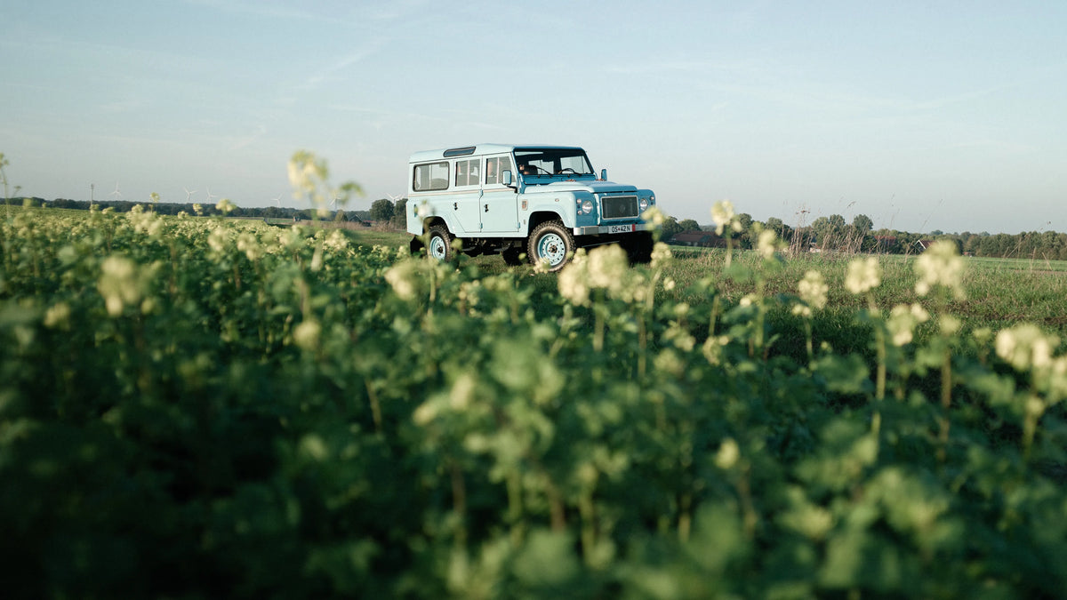 Miami Blue Defender 110 with its hardtop in an open field