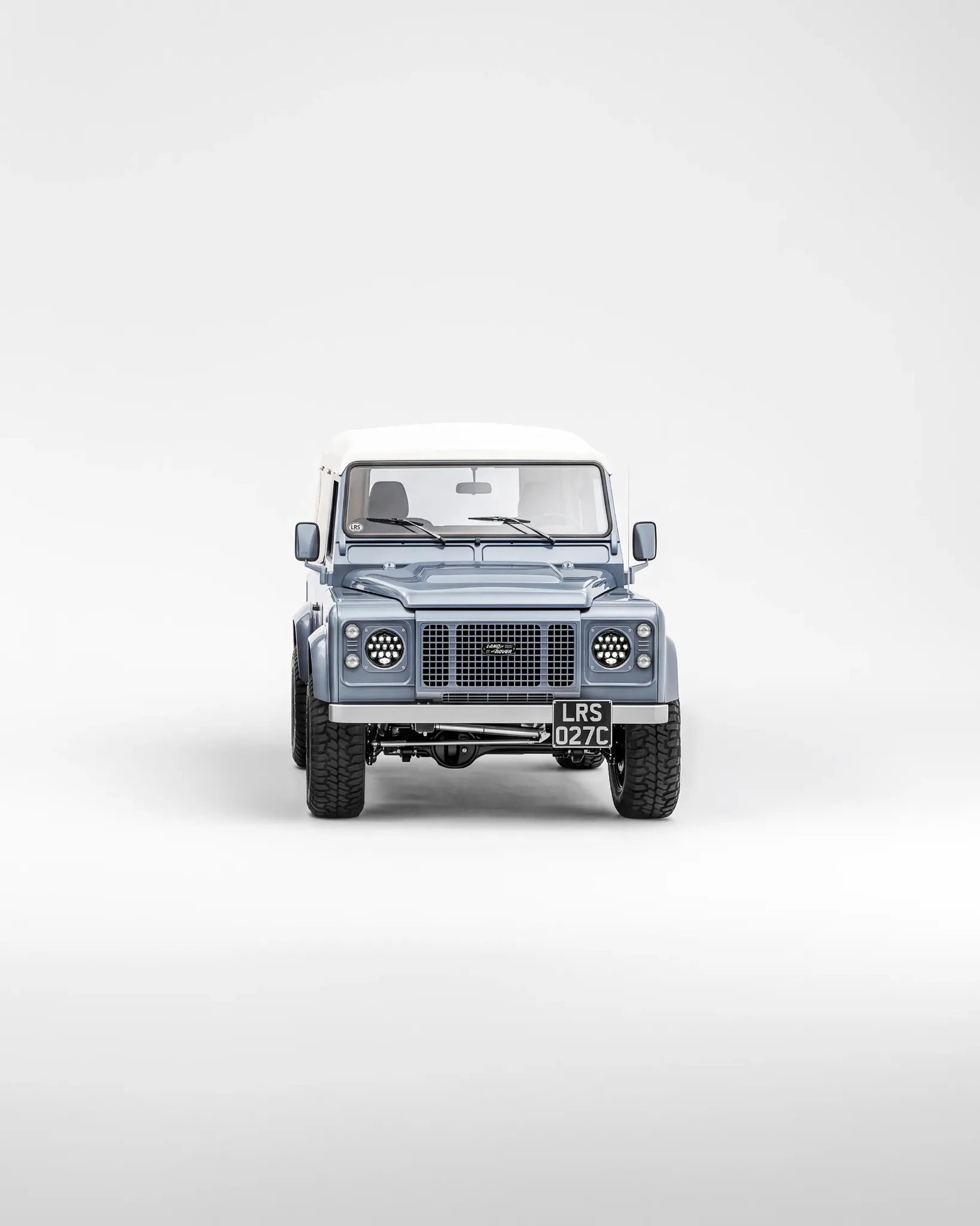 A blue Defender 90 with white roof